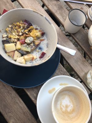 Cereals with almonds, fruits, Chia and soy milk, next to a Cappuccino with almond milk at Cafe Küstenkind in Greifswald