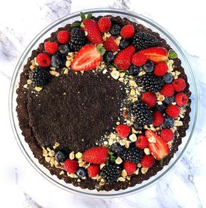 Gluten-free, Vegan, & Refined Sugar-free Hazelnut & Chocolate Pie 🥧🍫🍓- topped with mixed berries & extra crushed hazelnuts at Noor Healthy in Amman