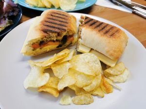 Cheese, tomato and pesto toasted ciabatta, with crisps. #vegan at Peacock Cafe in Stanmore