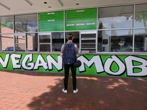 Restaurant front. There are three outdoor patio tables on the side. at Vegan Mob in Oakland