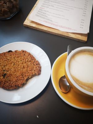 A vegan granola cookie and oat milk latte (I has already taken a bite from the cookie). at Temperance in Halifax