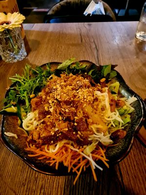 Rice noodles with veggies and tofu topped with several toppings at Soy in Munich