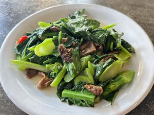 Stir-fried kale with shiitake mushroom stipe (50 THB)  at CMU Vegan - Kinphak Cafe in Chiang Mai