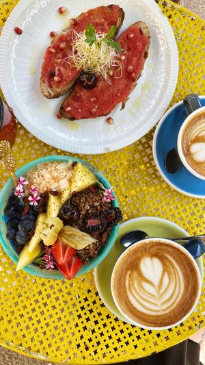 Blue tooth smoothie bowl, latte with oat milk, toasts with tomato paste  at Mama Carmen's Coffee & Bakery in Mallorca