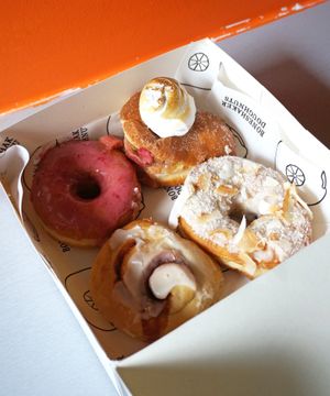 Raspberry + Mae West (rhubarb/cream/meringue) + No Sleep Till Brooklyn (lemon curd/coconut glaze) + Cinnamon Roll at Boneshaker Doughnuts in Paris