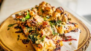 Herbed Rotisserie Jackfruit on our house made Breadfruit Sourdough with Hibiscus Marinara, local kale, slow roasted garlic, and housemade mozzarella with local basil, and olive oil at Journey Cafe in Kailua Kona