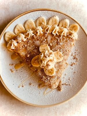 Indulge in our Banana Foster Crepe! 🍌✨  
Gluten-free crepe filled with buttery pie crumble, warm banana foster, rich caramel, and topped with creamy Macnut dairy-free premium at Journey Cafe in Kailua Kona
