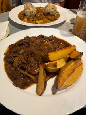 Au fond : Muschroom cream gulasch with bread dumplings Vegan
Devant : seitan sauce au vin, champignons, pomme frite at Landia in Vienna