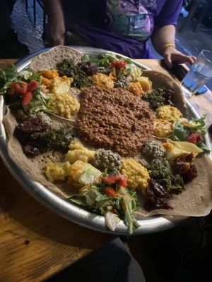 4 different vegan meals put on one big plate   at Lalibela in Berlin
