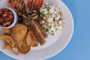 Vegan sausages, scrambled tofu, sautéed chestnut mushrooms, grilled tomato, house baked pinto beans, Maltese crust and EVOO at One80 in Mgarr