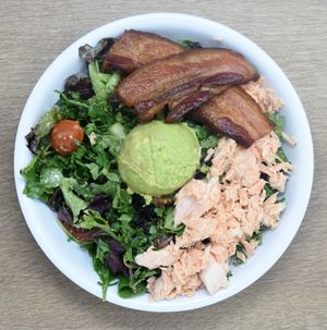 West Coast BLT - Organic Greens, Kale, Grape Tomatoes, Avocado, Cucumber, Bacon, Salmon, Creamy Honey Dijon at Revel Kitchen in Clayton