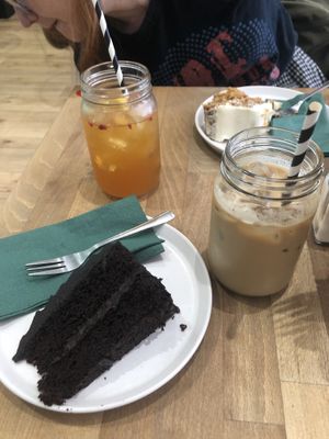 Vegan chocolate fudge cake and oat milk iced latte. Also pictured in background is peach iced tea and carrot cake (not vegan)   at Coffee House in Bishops Stortford