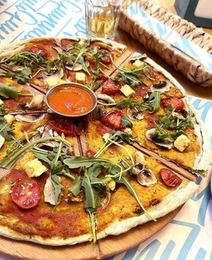 Vegan pizza: firm dough with vegan pesto, tofu, mushroom, cherry tomato, olive, oregano, arugula. at Garun in Yerevan