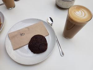 Cafe latte with oat milk and vegan chocolate cookie at Federal Cafe in Barcelona