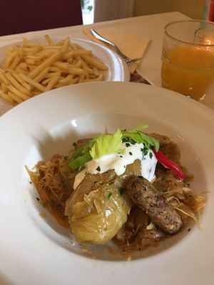 stuffed cabbage leave, on saukraut with cream and sausage (all vegan) - delicious!!!! at Napfényes Restaurant & Confectionery in Budapest
