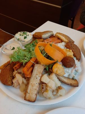 Plato para dos. (Incluye tofu, falafel, seitan, ensaladilla rusa, arroz salteado, vegetales, ensalada de patatas agridulce, queso rebozado y salsas) at Napfényes Restaurant & Confectionery in Budapest