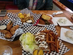 Left to Right Clockwise: Jalapeño poppers, Fried Okra, Half Sample Platter, Scoop of mashed potatoes, Biscuit and Gravy, Shrimp Po' Boy at Souley Vegan in Oakland