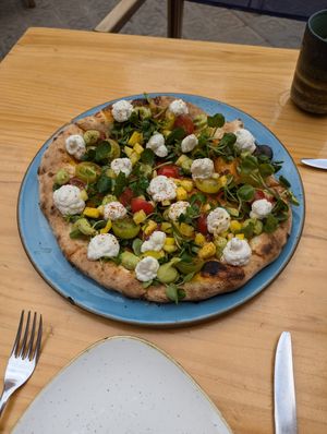seasonal pizza with mango, avocado cream, fermented nut cheese, tomatoes, greens & Tajín Clásico seasoning at Blu Bar in Barcelona