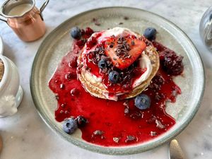 Berry pancakes with blueberries, strawberry and cacao nibs - this was dreamy. Best vegan pancakes I've had.  at Beck Hall in Malham