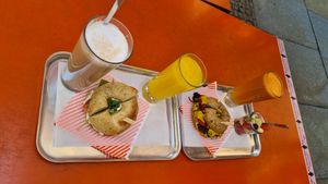 Latte macchiato, tomato mozzarella bagel, orange juice, vegan bagel, juice of the day, small fruit salad at Bagel Brothers in Leipzig