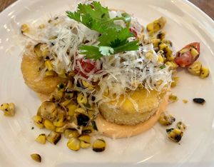 Mexican Corn Cake appetizer - cashews, cherry tomatoes, grilled corn, lime, chili, coconut queso  at Wildseed in San Francisco