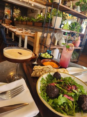 Mezze appetizer plate with espresso martini and blueberry n/a drink. Live plant decor in spacious layout. at Wildseed in San Francisco