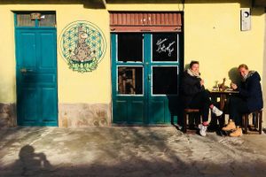enjoying a delicious cup of coffee in the sun, in early spring outdoors.  at Llama Cafe in Uyuni