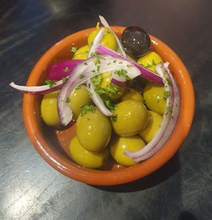 Starter: Dish of Marinated Olives - Green and black olives (with stone), marinated in olive oil, pink peppercorns, red onion and garlic at Giannis in Scarborough