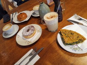 Chocolate donut with praline feeling. Spinach Wähe, Schoggibrötli, Kurkuma Latte and Cappuccino at Sprössling in Zurich