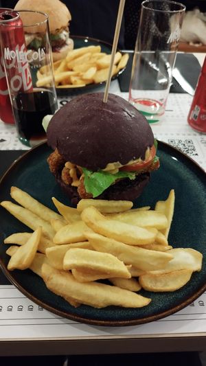 Burger con finto pollo, salsa al curry, salsa buns, insalata pomodoro. Accompagnato da patatine fritte at Buns in Alghero