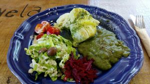 Trouxas de couve com bulgur e alheira vegetariana dentro. Acompanhado com um esparregado de espinafres, lentilhas e leite de cocô. at Mela Canela in Sintra