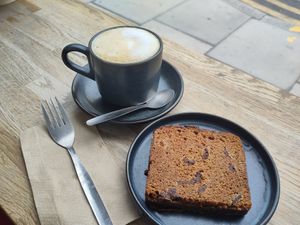Oat milk cappuccino and banana bread at Cinnamon Coffee Shop in London