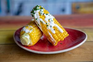 Charred Corn on the Cob (gf, vg)
Topped with a Garlic & Lemon Crema 

 at Fancy Hank's in York