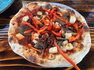 Custom vegan pizza with red peppers, caramelized onions, vegan feta, and vegan sausage.  at The Privateer in Oceanside