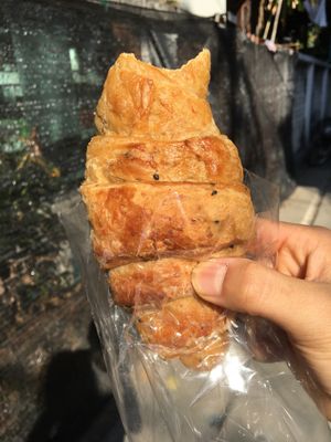 Whole-wheat croissant (with a sneaky bite out of it) at Da's Home Bakery in Chiang Mai