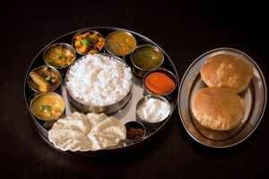 South Indian Thali - A Platter of vegetable sagu, steamed rice, vegetable sambar, kara kozambu,rasam, poriyal, kootu, curd/ butter milk, pappad, pickle and sweet dessert at Krishna Vilas in Utrecht