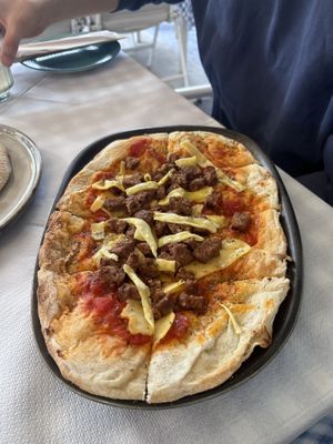 Vegan pizza (slices of cheese with cut up vegan burger patty )  at Cafe12 in Crete