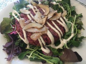 Beet Burger Salad! A perfectly grilled beet patty resting on freshly picked and local salad with an amazing variety of big greens and herbs! at Angelhearts Donuts in Ithaca