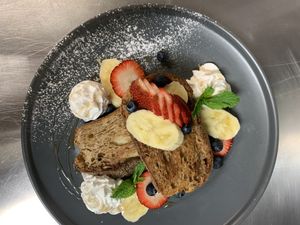 The Den’s French Toast. Thick slices of ciabatta bread served with fresh berries, sliced banana, and drizzled with maple syrup at Zen Den in Mooloolaba