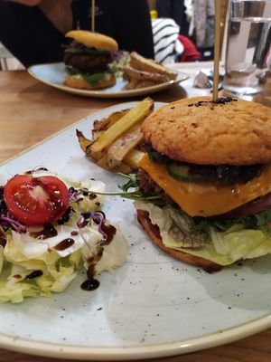 smoked bean burger, with orange bbq sauce and vegan cheese. chips ordered separate on the menu at Élelem Etterem in Budapest