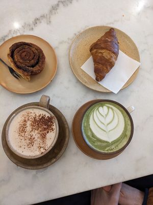 Cinnamon roll, croissant, chai latte, and matcha latte at Mica Coffeebar in Haarlem