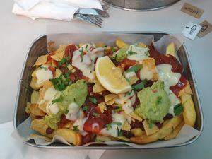 Chilli 'Non' Carne Loaded Chips: Plant based mince with chunky tomato, beans, and onions, topped with guacamole and crushed tortilla chips at MAN - The Lion and Antelope - T3 in Manchester