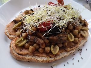 Biodesem-olijfbrood met zuiderse Cashewspread kikkererwten, aubergine, paprika, preischeuten en groene olijven at HART in Antwerpen