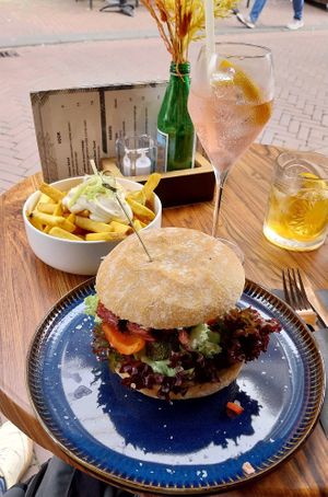 Burger with 3d-printed steak, truffel fries, and aperol no-spritz. at New Vegas in Haarlem