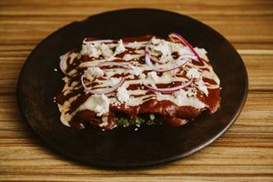 ENMOLADAS POBLANAS: Tortillas de maìz criollo nixtamalizado con relleno campesino ( guisado de setas y elote) bañadas en salsa de frijol al chipotle, con crema y queso vegano).  at Pali Pali del Valle in Mexico City