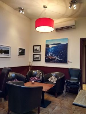 Rear seating area and local artwork at Caffe Eleganza in Ross-on-wye