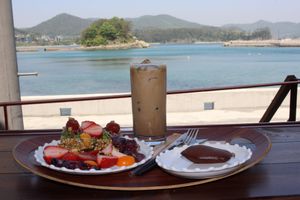 Plant-based latte, small brunch and one of her baked goods at Gwanpo 60 in Geoje
