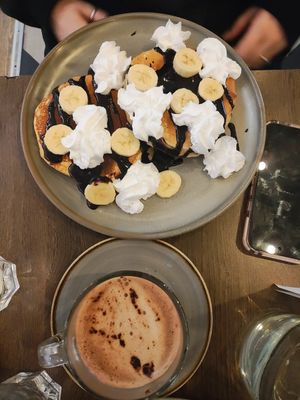 two pancakes with chocolate sauce, banana, and whipped cream and a hot chocolate. the hot chocolate had that distinctive "vegan chocolate" taste which i'm not personally a fan of at Vegivores in Reading
