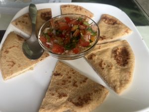 Hummus topped with salsa served with pita sliced  at Aum Cafe in Varanasi