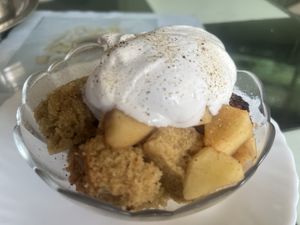 Spice cake with warmed apple cinnamon slices topped with vegan cream  at Aum Cafe in Varanasi